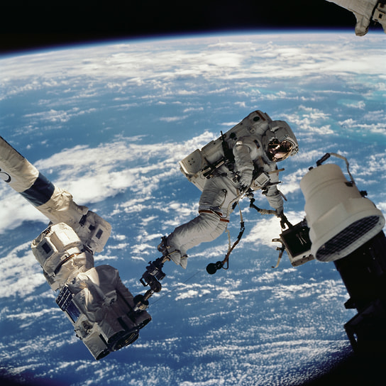 Астронавт Дэвид Вулф, специалист миссии STS-112, держит внешнюю камеру Starboard One (S1)