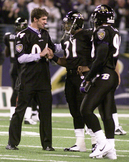 Майкл Фелпс приветствует полузащитника Baltimore Ravens Джамала Льюиса (31-й номер) перед матчем Baltimore Ravens против Cleveland Browns в Балтиморе (США), 2004 год