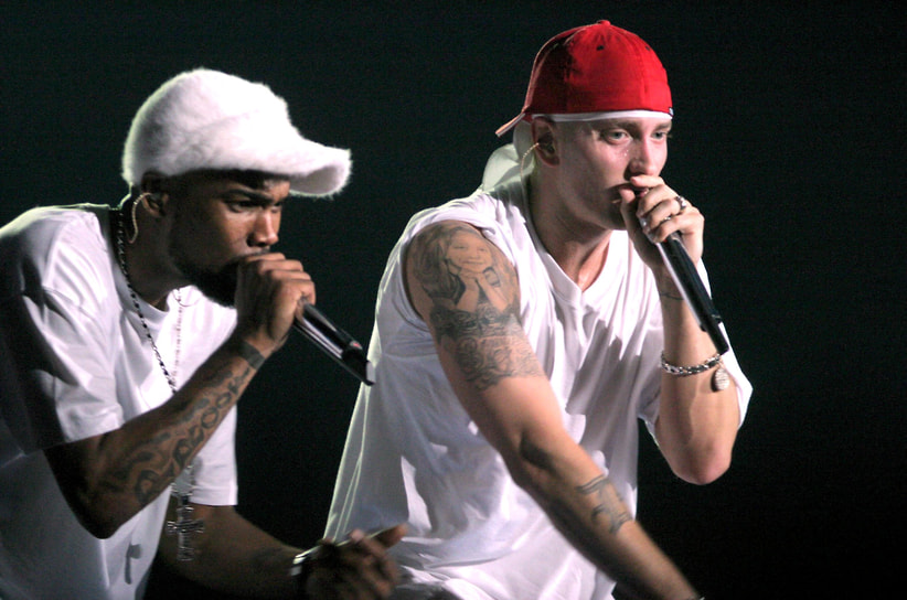 Первоначально музыкант выступал под псевдонимом «M&amp;M», представлявшем собой инициалы его имени Маршалл Мэтерс. В дальнейшем оно превратилось в «Eminem»
На фото: с рэпером Proof на концерте в Амстердаме, 2003 год